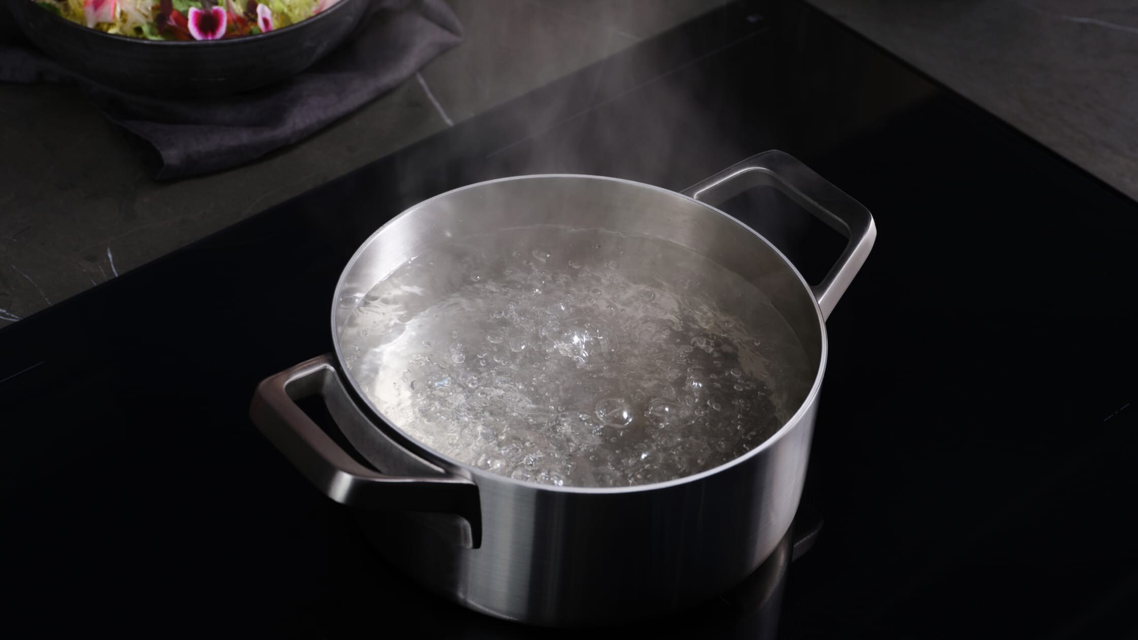 En gryta med kokande vatten på en induktionshäll.