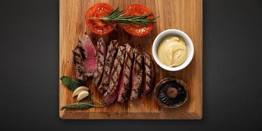 En middag med grillad stek upplagd på en planka