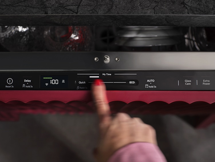 Närbild på kontrollpanelen QuickSelect på en AEG diskmaskin. Finger som justerar programtid.