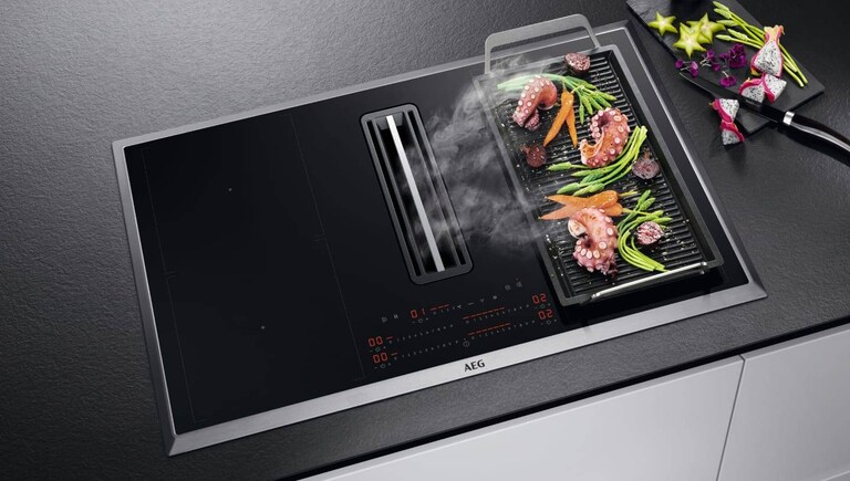 Matlagning på en planchagrill placerad på en AEG-häll.