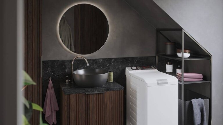 Toppmatad AEG-tvättmaskin i ett badrum.