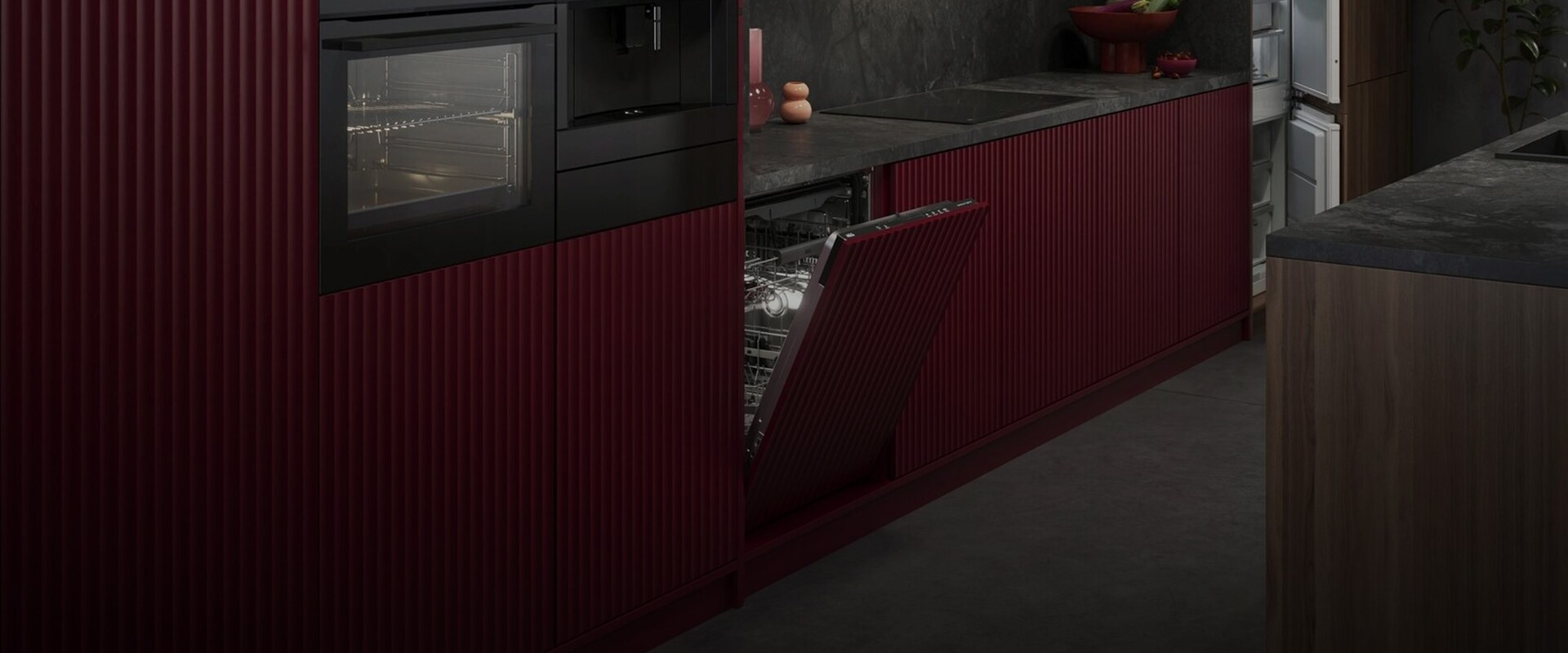 Stilren köksvägg med integrerade AEG-vitvaror inklusive ugn, kaffemaskin och en halvöppen diskmaskin med röda räfflade fronter.
