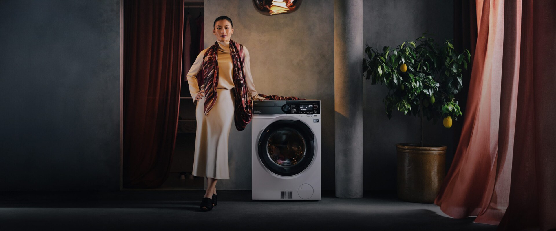 Kvinna står bredvid tvättmaskin med torktumlare